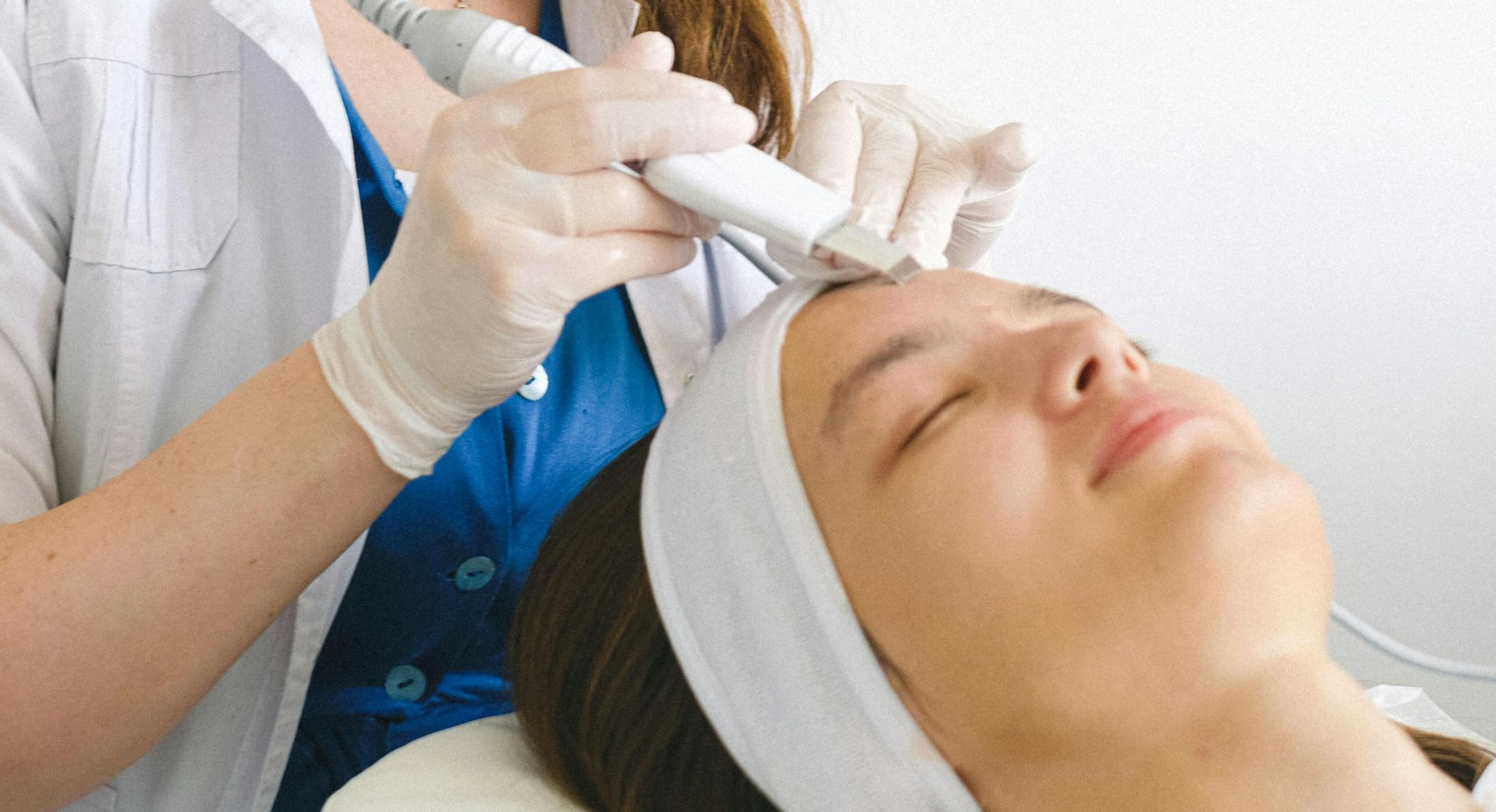 A beautician performs a facial treatment on a client in a clinic, enhancing skincare and rejuvenation.
