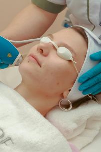 Woman receiving beauty treatment in spa with skincare laser device.
